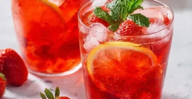 Selbstgemachte Erdbeer Limonade in einem Glas mit frischen Erdbeeren.