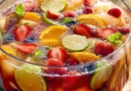 Erfrischende Bowle in einer dekorativen Schüssel mit Früchten und Eis.