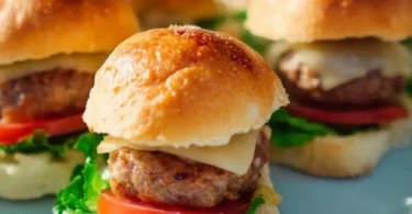 Ein Teller mit verschiedenen Mini-Burgern garniert mit frischem Gemüse und Saucen.