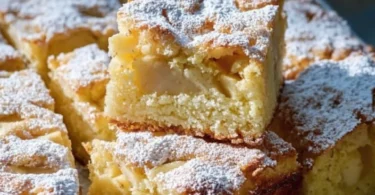 Ruck Zuck Apfelkuchen vom Blech auf einem weißen Teller mit Äpfeln
